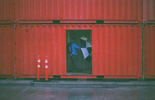 shipping container man holding umbrella inside the intermodal container container